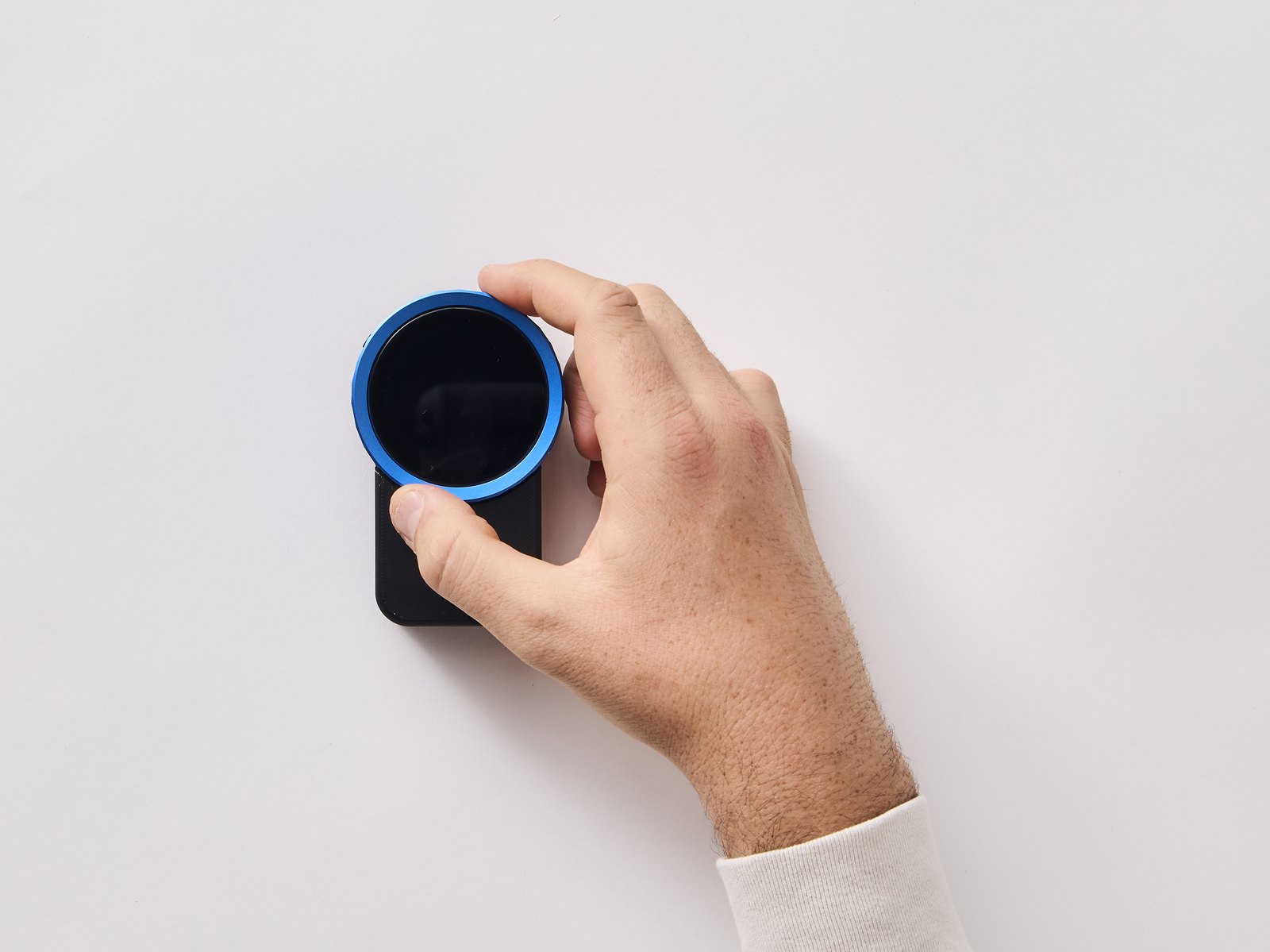 A hand gripping the dial of the Trepo device to turn it