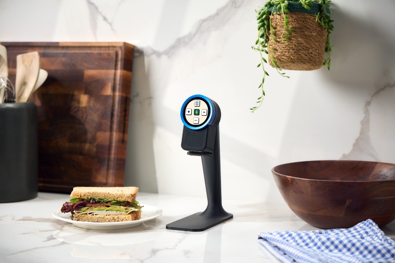 The Trepo device on its countertop stand beside a plated sandwich