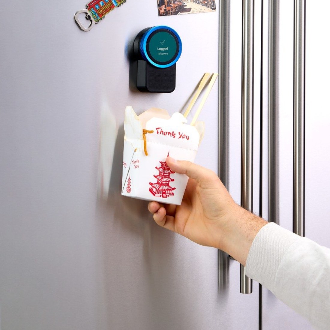 A takeout box held up to the Trepo device on the fridge door, which reads Logged — leftovers